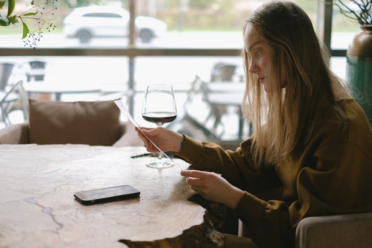 Woman Looking At Menu In Restaurant 