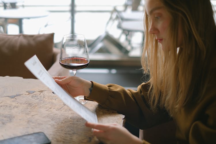 A Woman Looking At A Menu