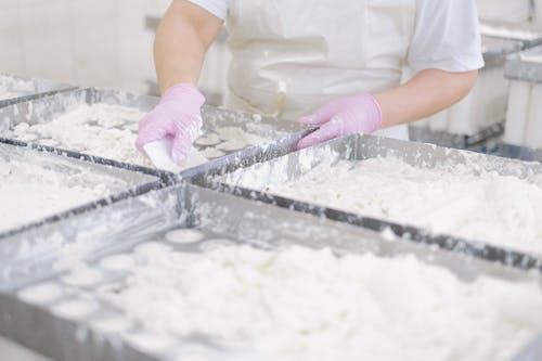 Free A Person Wearing a White Apron and Latex Gloves Stock Photo
