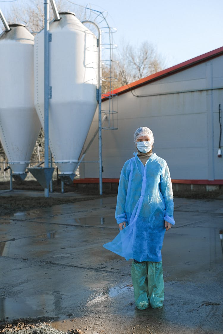 A Person In Plastic Suit Standing Outside The Production Plant