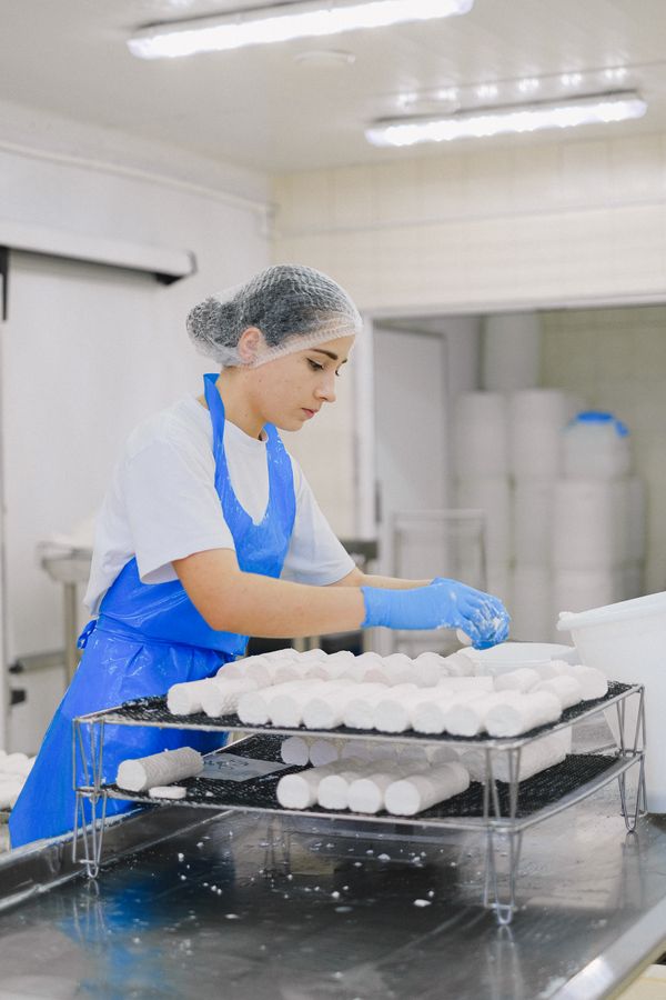 Cheese production line worker with protective gear
