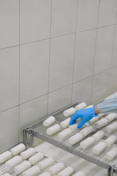 在清洁、无菌的环境中，戴着乳胶手套的手正将纱布卷搬运到金属架上