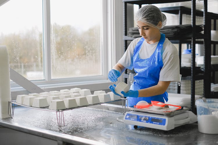 Woman In Uniform Working In Food Industry