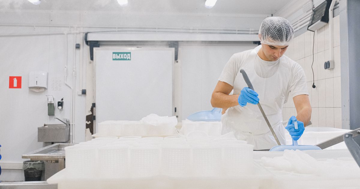 Hygienefachkraft in steriler Schutzkleidung kontrolliert die Reinigung in einem Lebensmittelbetrieb