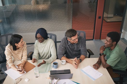A diverse team of professionals engaged in a collaborative discussion around a conference table in an office.