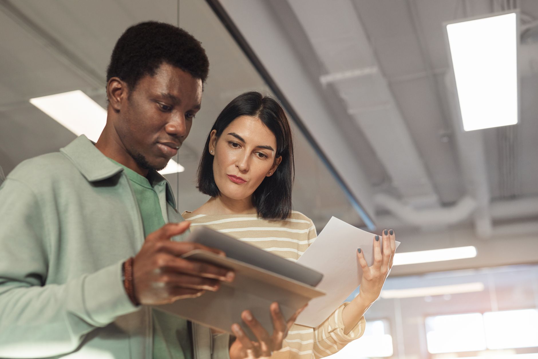 Two people reviewing a job description on a tablet, annotating the required skills and mapping them to practice tasks