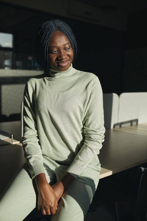 A Woman in Gray Sweater Sitting on the Table