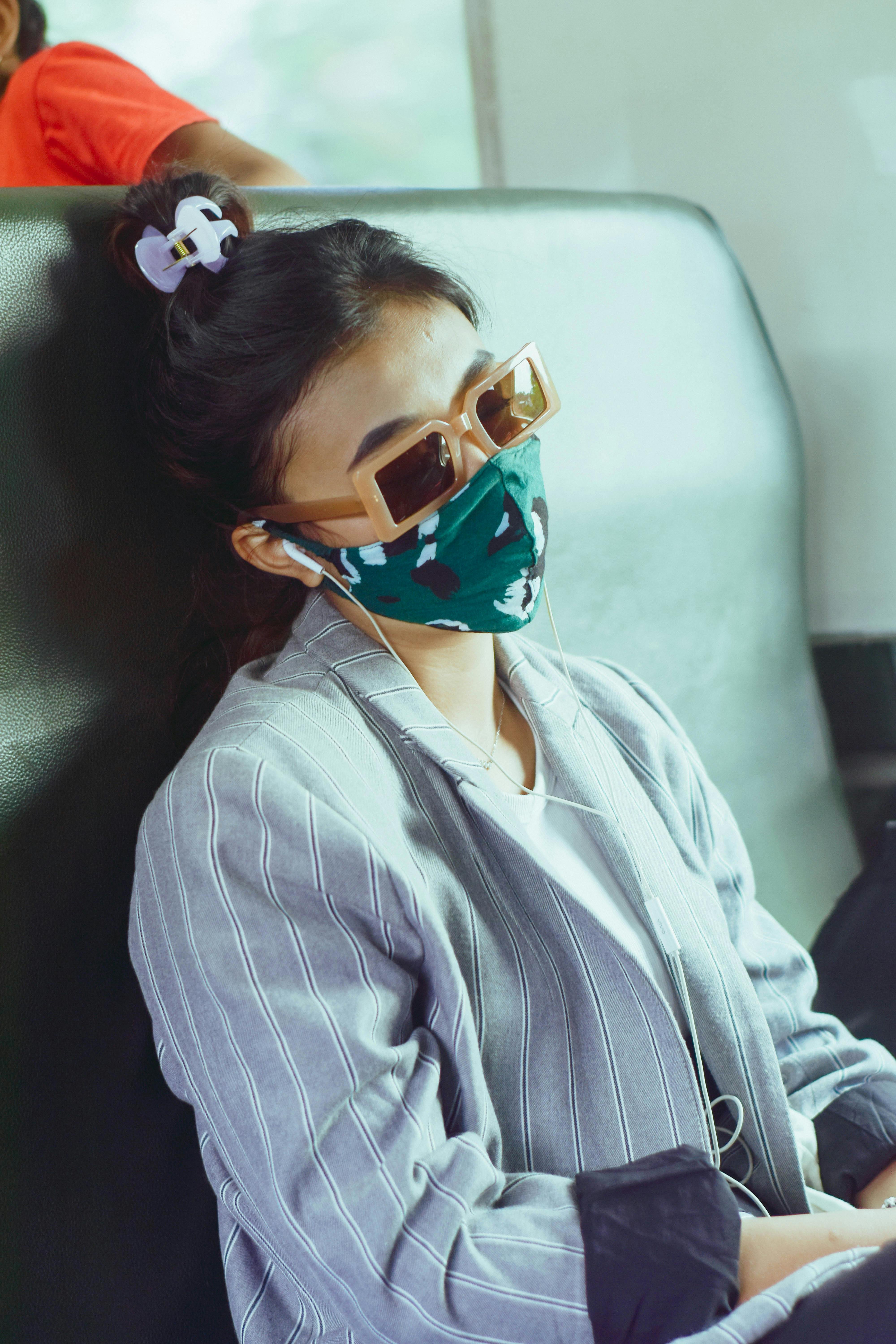 Free A Woman with Face Mask Listening to Music Lessons