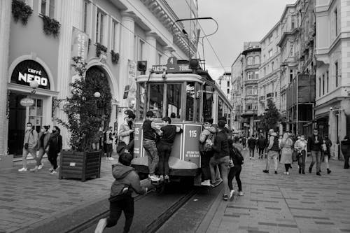 Grayscale Photo of People Riding on Tram