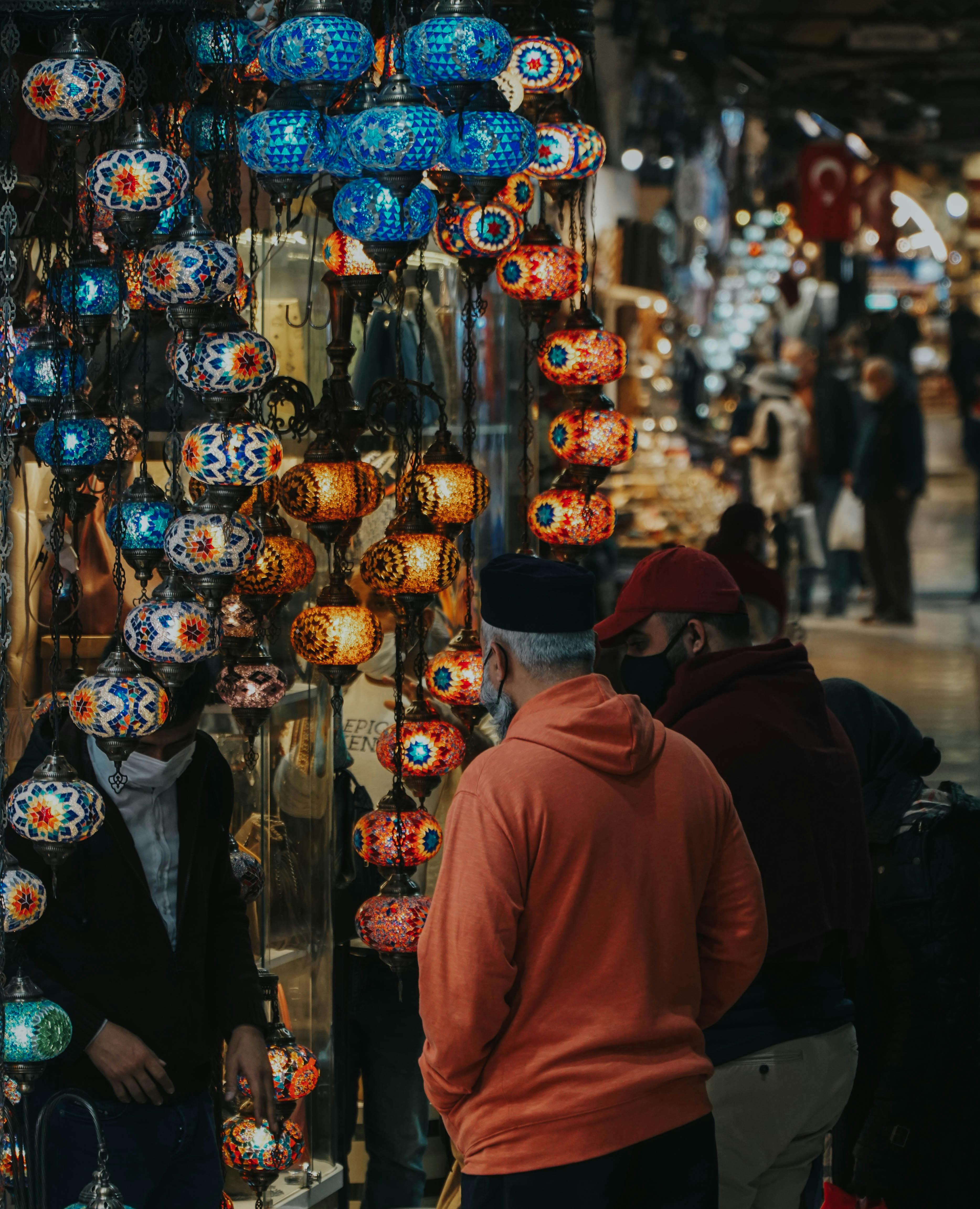 men wearing hoodie and cap looking at lanterns