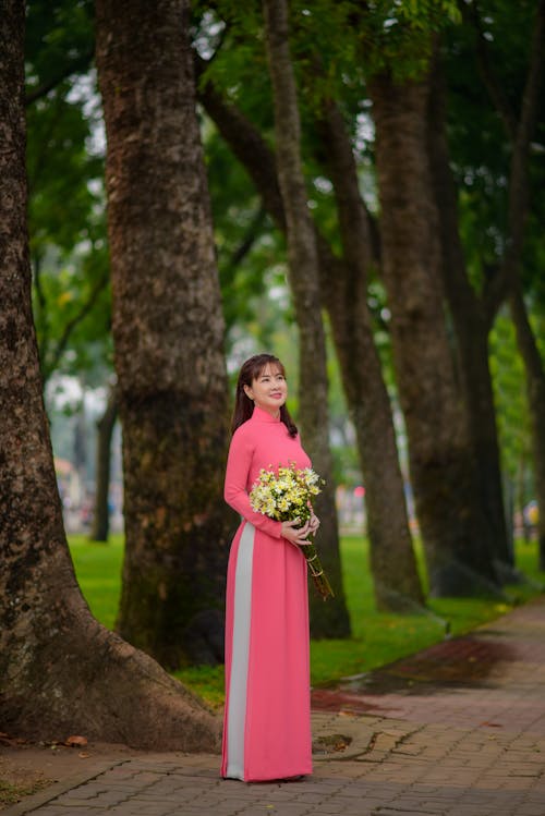 Model in a Pink Dress Holding a Bouquet of Flowers