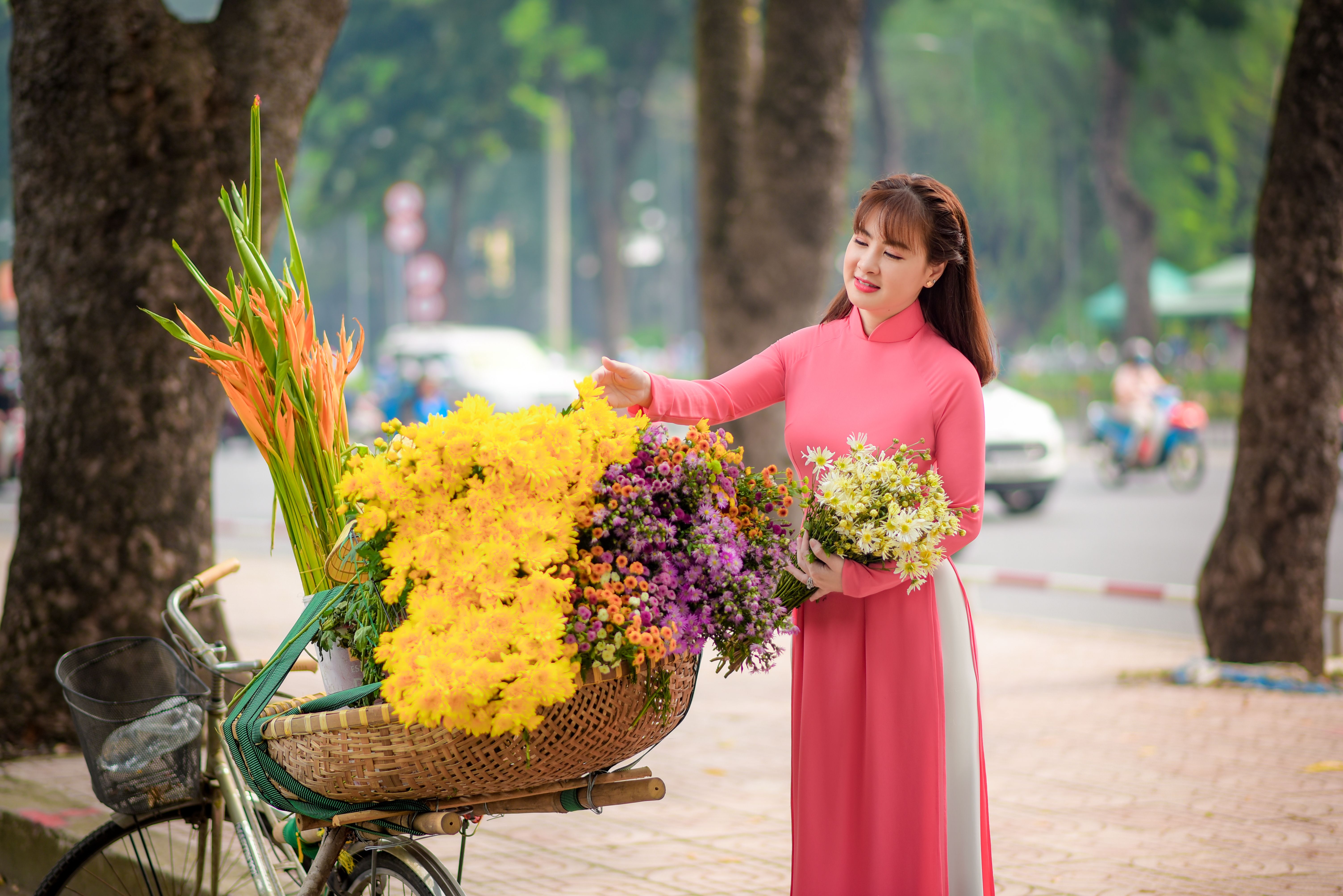 Woman in Pink Dress Holding a Bunch of Flowers · Free Stock Photo