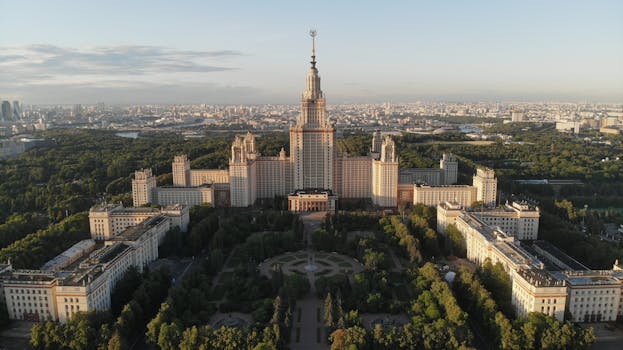 Stunning aerial view of Moscow State University and cityscape against a blue sky.
