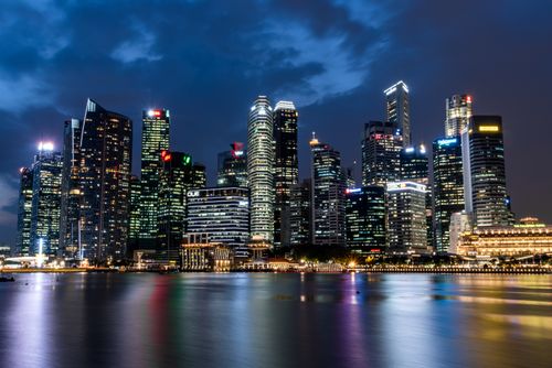 Free Illuminated Singapore skyline reflecting beautifully on waterfront at night. Stock Photo
