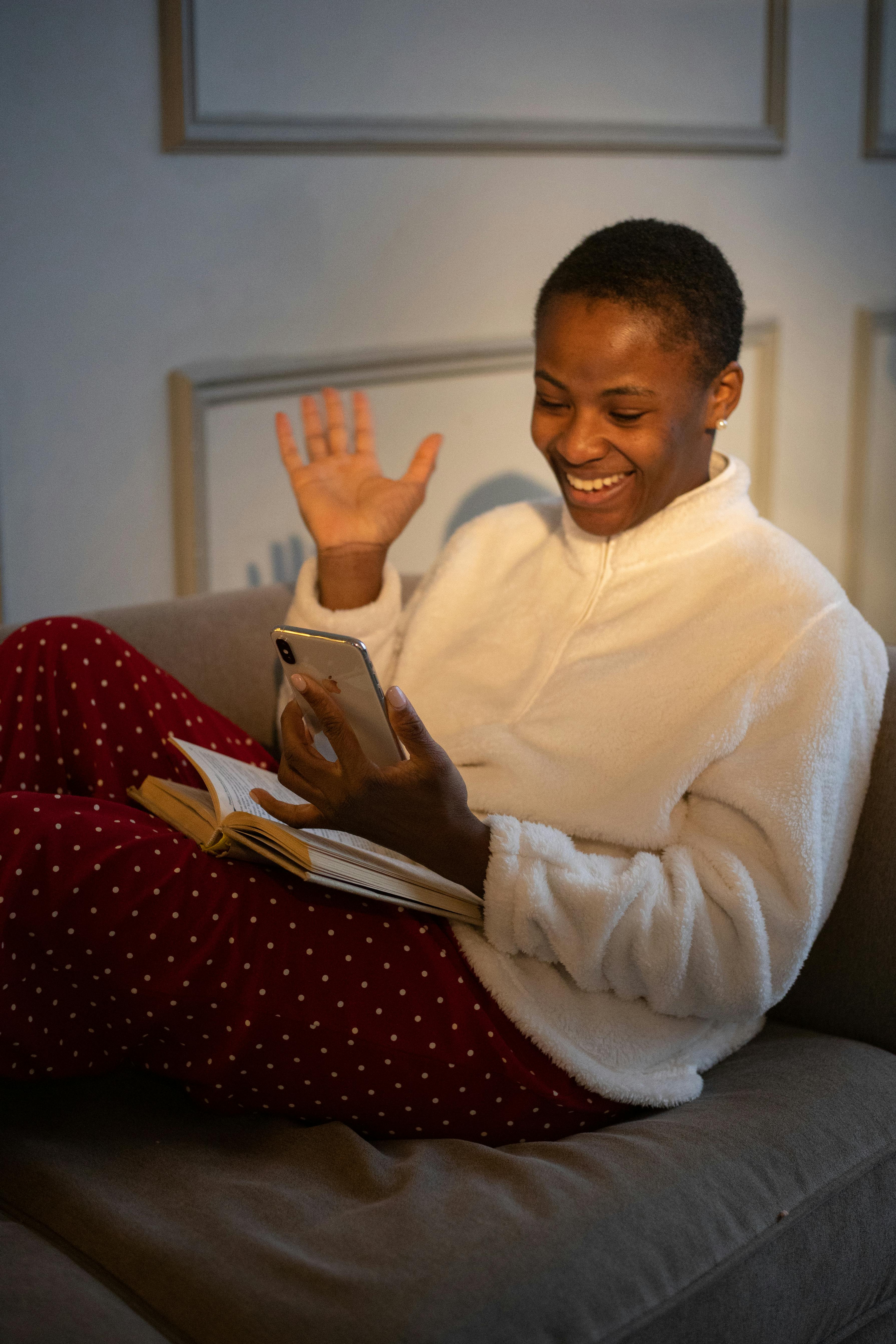 woman in white sweater holding a mobile phone