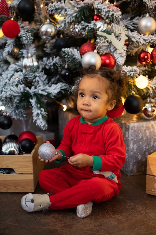 Child Sitting Under a Christmas Tree