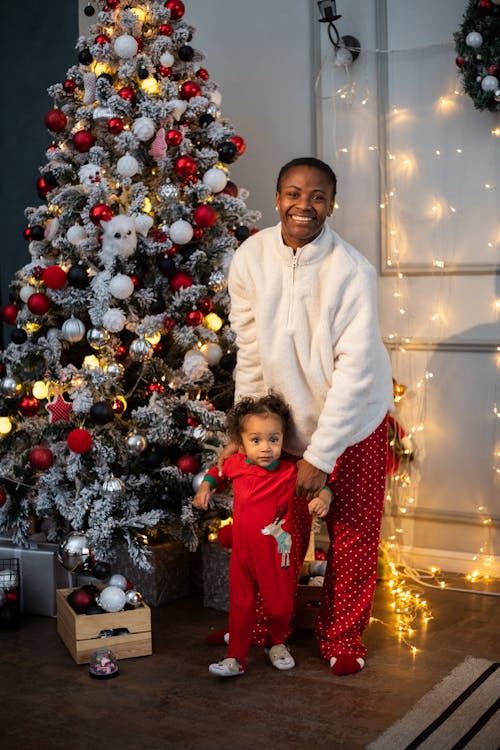 Mother and Child Standing Beside a Christmas Tree