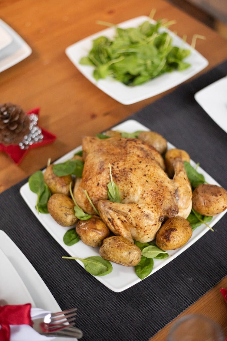 Roasted Chicken And Potatoes On White Ceramic Plate