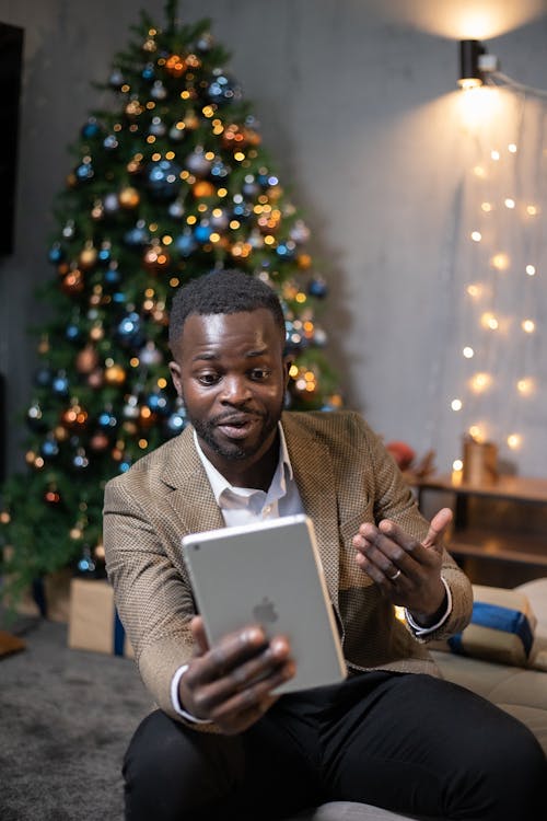 Man In Brown Coat Holding A Tablet