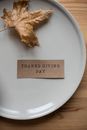 Plate with carton postcard and dry leaf