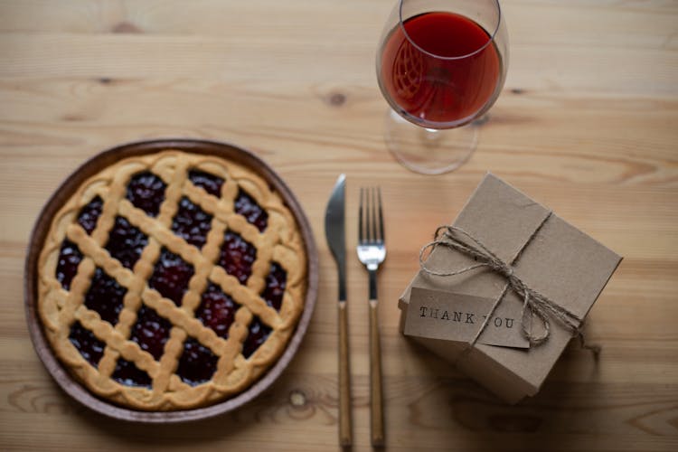 Delicious Pie Near Glass Of Wine And Gift Box On Table