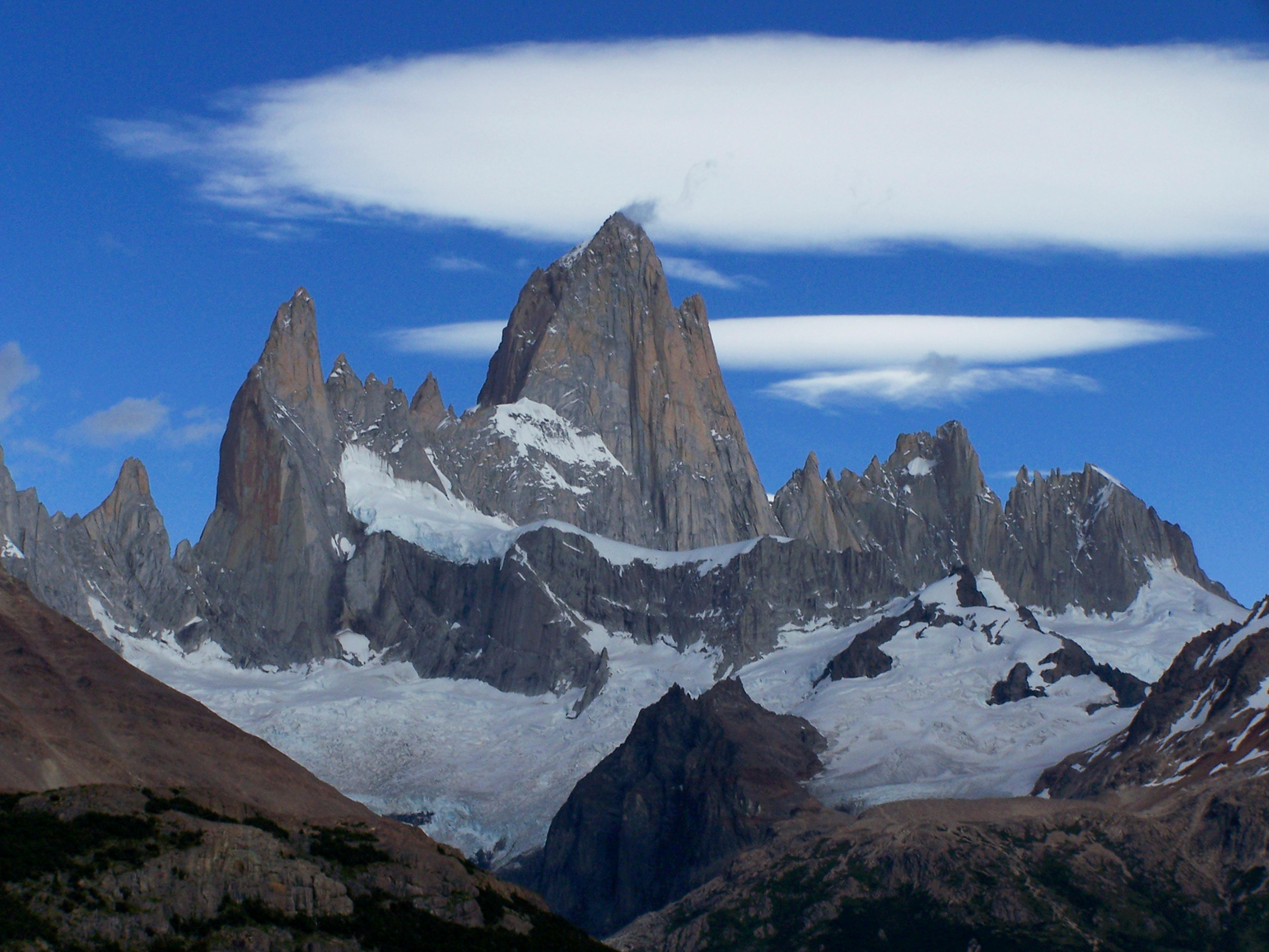 Majestic Mount Fitz Roy with snow-covered peaks against a vibrant blue sky in Patagonia, Argentina.