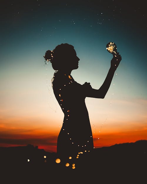 Free Woman Holding Lit-up Light String Silhouette Photography Stock Photo