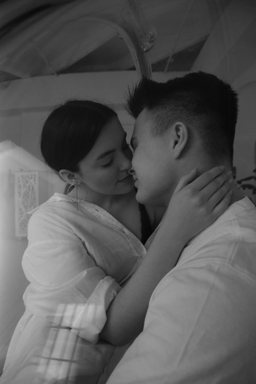 Free Black and white loving young couple in casual clothes embracing and caressing each other gently in light room Stock Photo