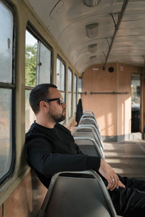 A Man in Black Sweater Sitting on Gray Chair