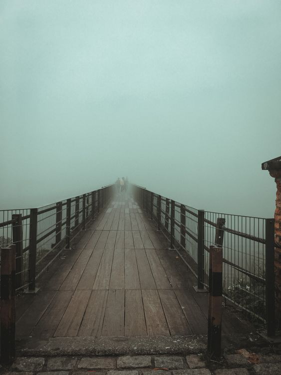A wooden bridge extending into thick mist, illustrating taking the next clear step while trusting Yahawah with an unseen future