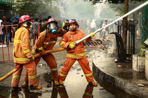 Free Firefighters Holding a Fire Hose Stock Photo