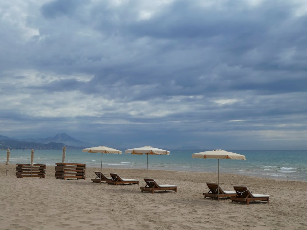 Beach Chairs with Umbrellas Under a Cloudy Sky