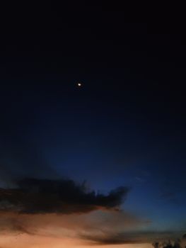 夜空中，月亮和星星的宁静景色，带着淡淡的日落余晖