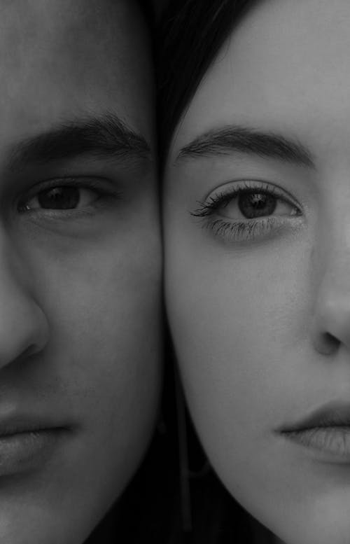 Crop young calm couple faces together
