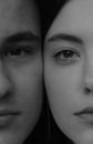 Crop young calm couple faces together