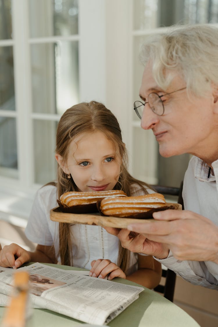 A Man And Girl Smelling The Bread