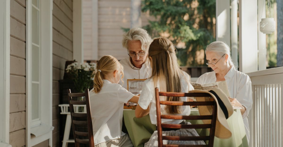 Multi-generational family sharing a moment on a sunlit veranda, capturing togetherness.