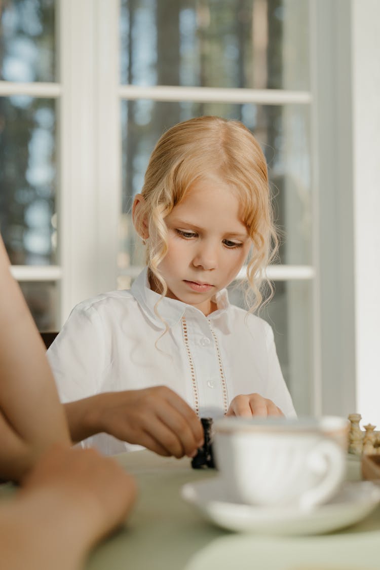 Child Holding A Chess Piece