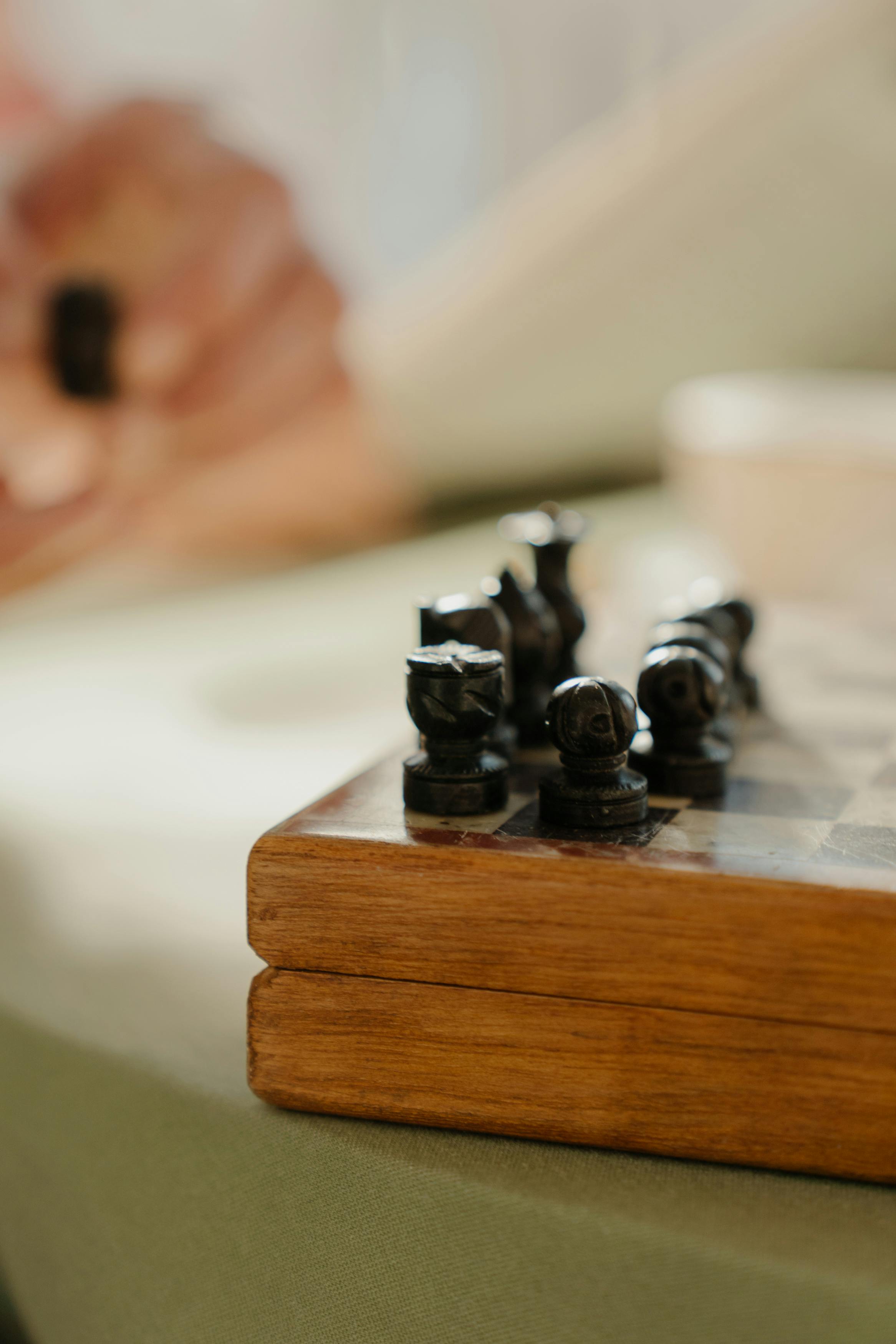 black chess pieces on brown wooden chess board