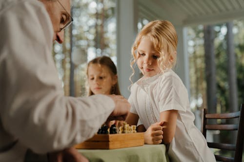 Mädchen Im Weißen Hemd, Das Schach Mit Jungen Im Weißen Hemd Spielt