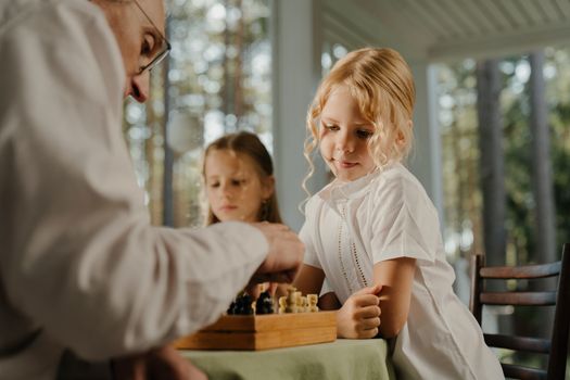 孩子们和老年人在室内下棋时捕捉到的家庭时刻