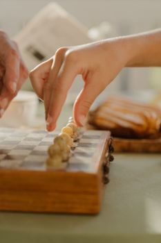 室内特写双手玩棋盘游戏，营造战略氛围