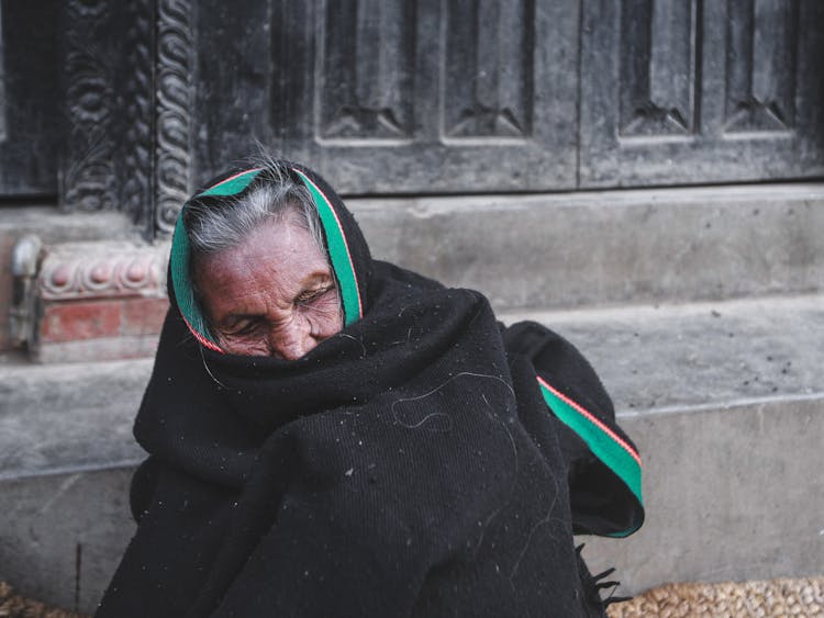 Unhappy Senior Ethnic Woman In Warm Fabric On Street