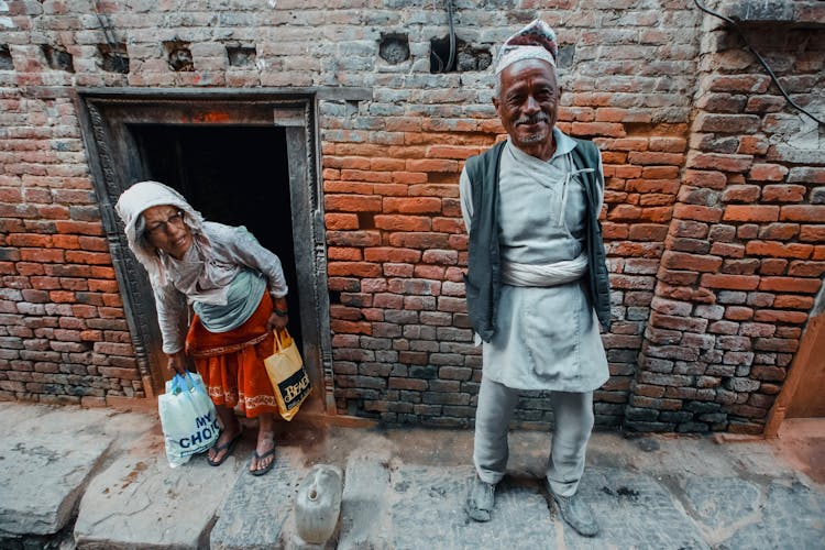 Ethnic Man And Woman On Narrow Walkway In Old Town