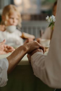 一对老夫妇在舒适的室内家庭聚会上手牵着手