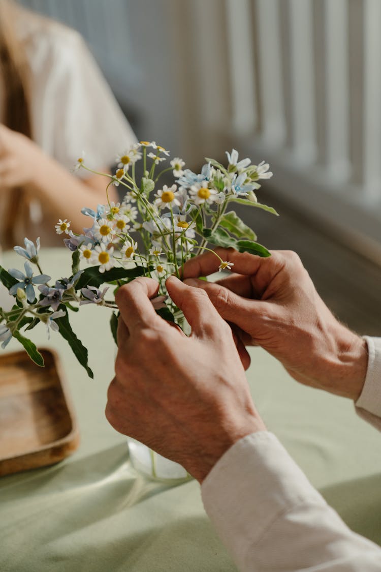 Person Holding Small White Flowers