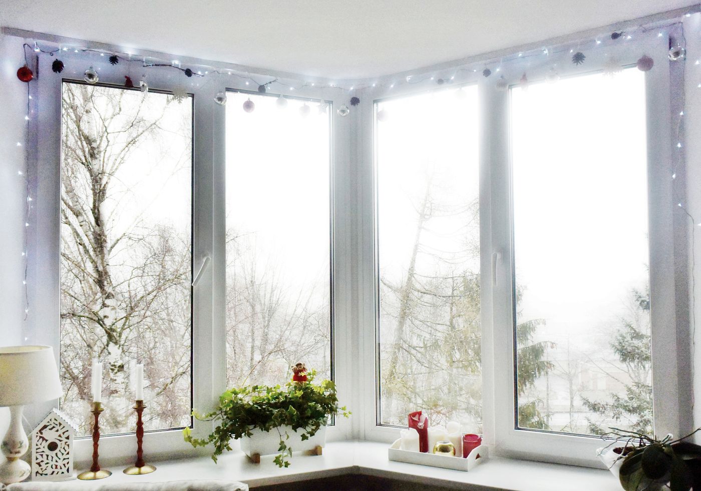 Grandes fenêtres blanches décorées avec une guirlande lumineuse pour Noël