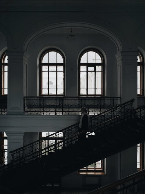 Free Grayscale Photo of a Person Walking Down the Stairs Stock Photo