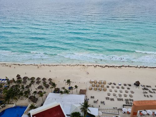 Free Aerial view of a resort beach with people enjoying the summer by the seashore. Stock Photo