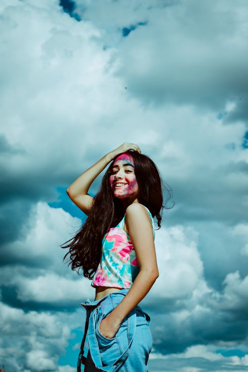 Free A happy young woman with colorful face paint enjoying a bright day outdoors. Stock Photo